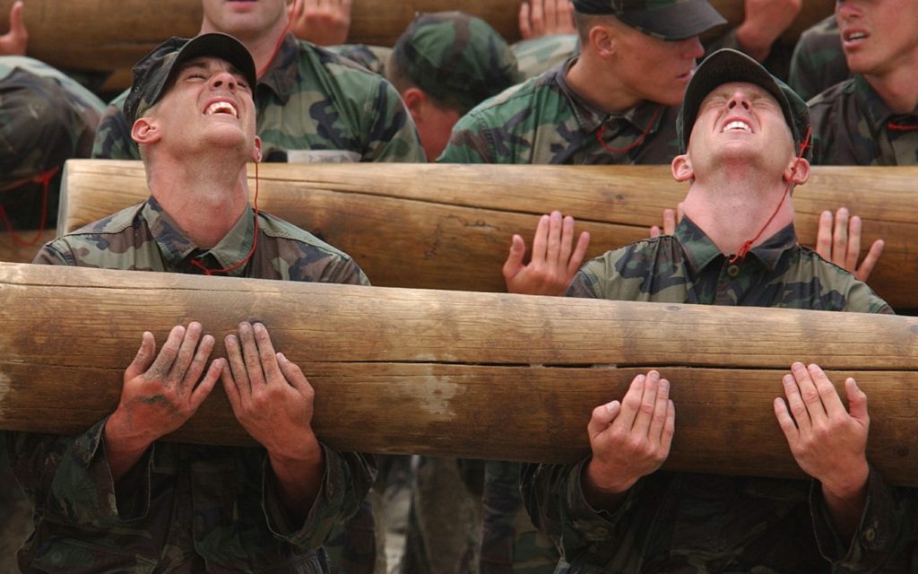 Military recruits holding a log
