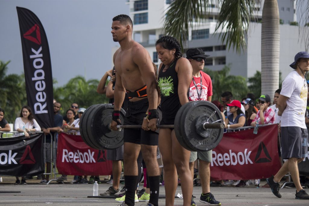 man and woman lifting a barbell